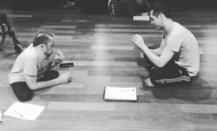 Black and white photo of two dancers sitting on the floor
