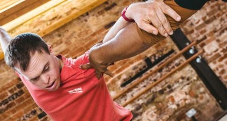 Chris, dressed in a red t-shirt, is dancing in a studio