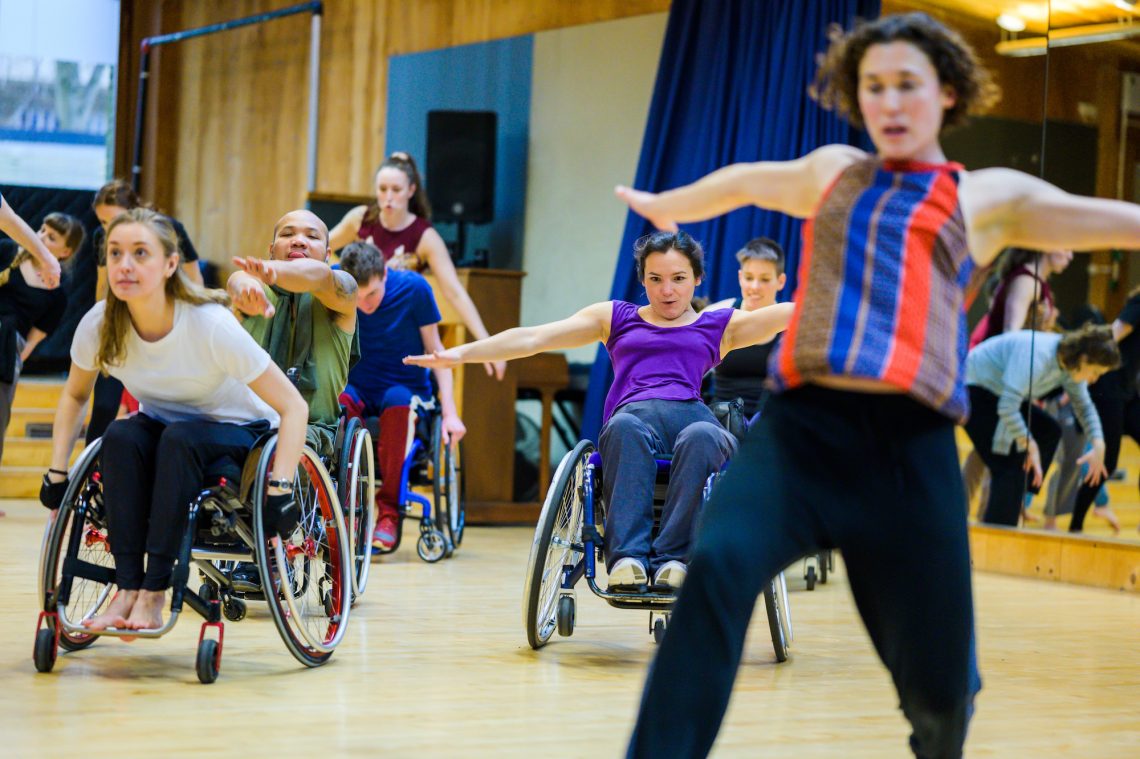 A mixture of wheelchair and standing dancers in the studio