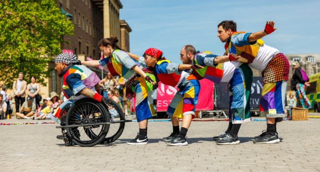 Fiver dancers in line as they perform outside.