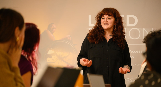 A white person stands and delivers a presentation.