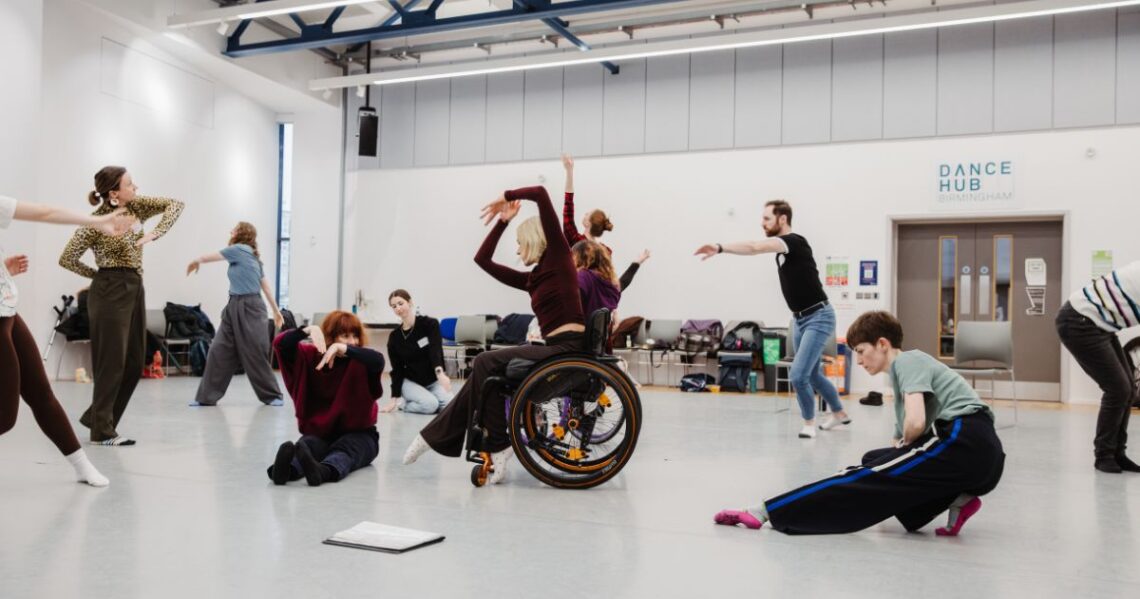 Standing and Wheelchair dancers moving together in a dance studio