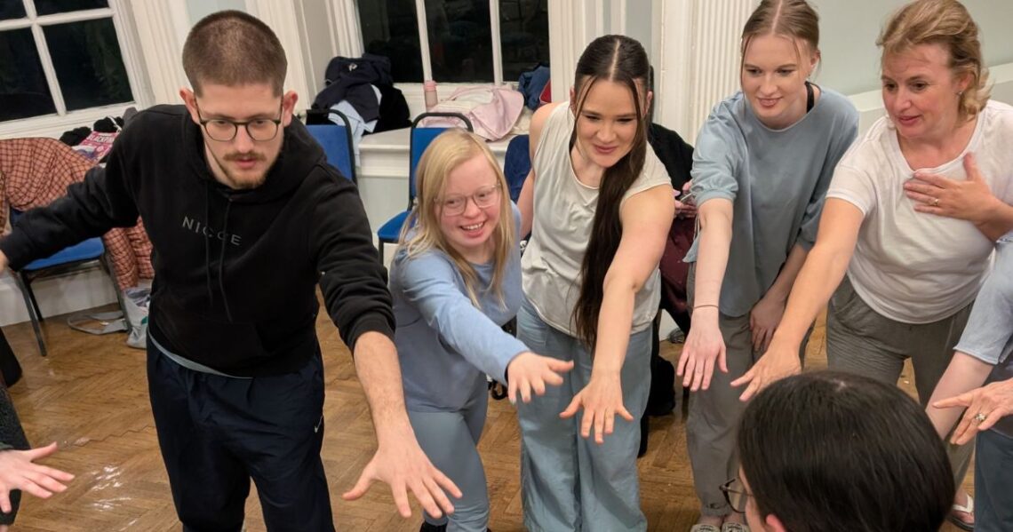 Stopgap team and dancers learning hands in for group energy